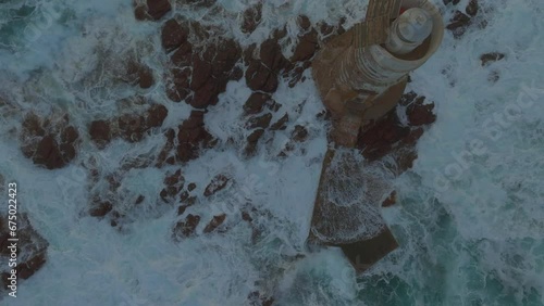 Mangiabarche Lighthouse, Sardinia: Fantastic aerial view from above discovering the beautiful lighthouse and the fury of the waves during the sunset. photo