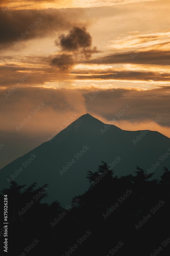 Fuego Volcano making a small eruption with the light of a sunset