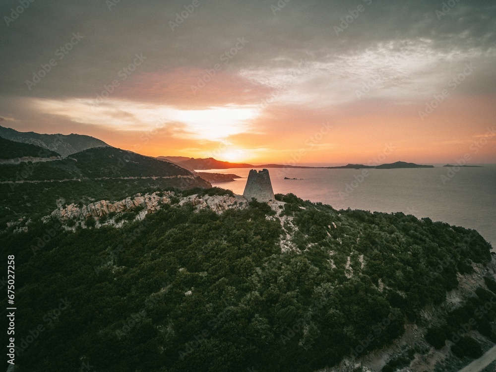 Tranquil landscape captured at sunrise with a watchtower on the coast of Italy