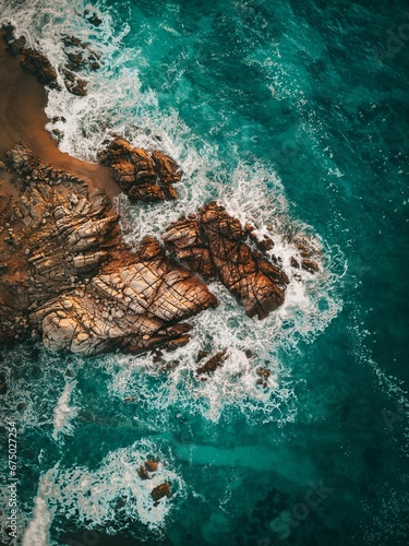 Aerial view of the coastline with beautiful waves and color contrast