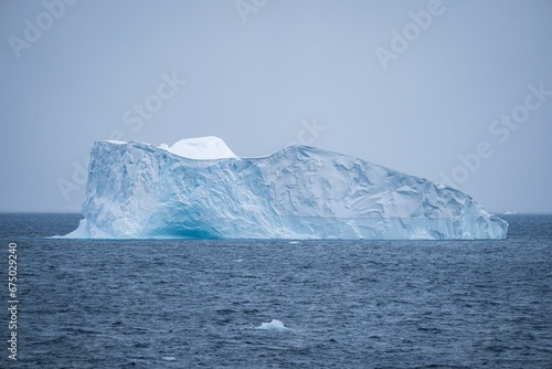 Scenic view of an iceberg in the sea on a cloudy day
