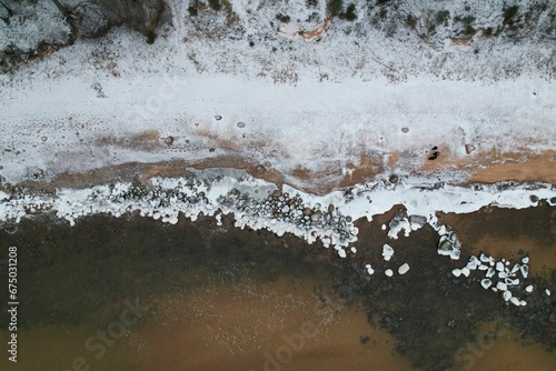 Aerial view of a beach with a thick layer of frosty ice covering the sand