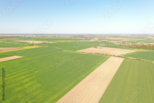 Aerial view of a rural landscape with cultivated fields, crop lines, and other farmland