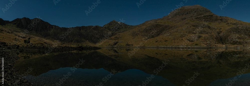 Awe-inspiring aerial view of a tranquil lake surrounded by majestic mountains: Snowdon Pano at night