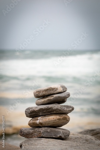 stacked rocks near the beach by the ocean photo by adam macraes photo