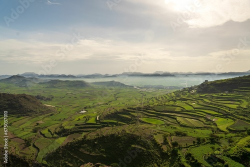 Stunning panoramic view of Ibb, Yemen, featuring a vast valley surrounded by majestic mountains