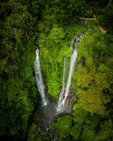 a couple of waterfalls running down a lush green forest back