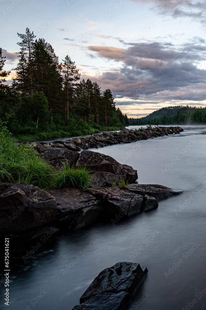 River in the wilderness next to a forest area at dusk in Norrland