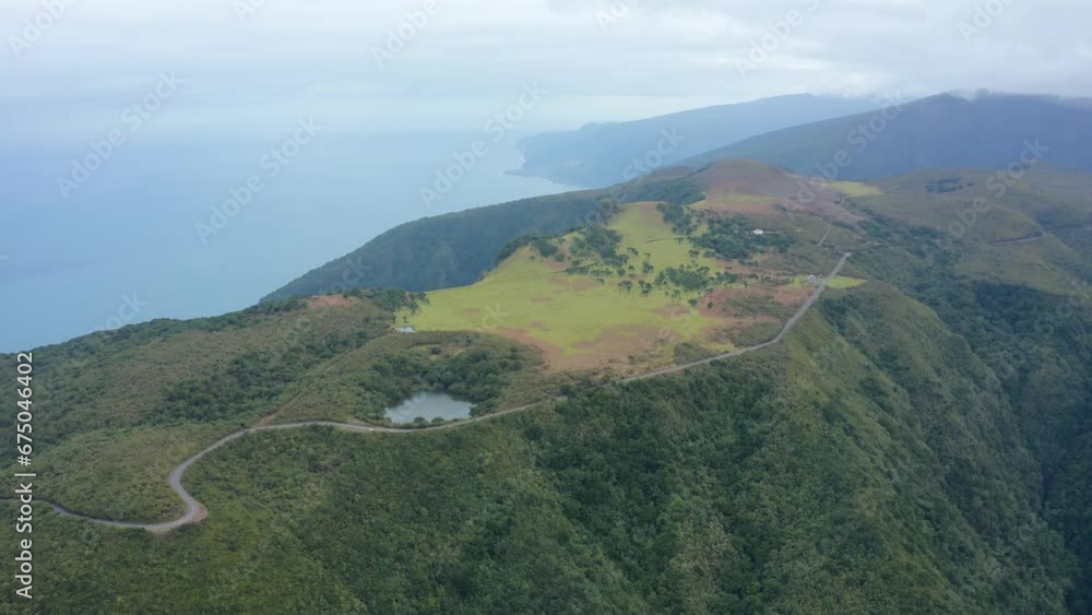 Aerial top view video of the lake surrounded by trees in the forest next to the road Aerial top view video of the lake surrounded by trees in the forest next to the road