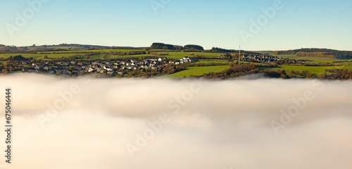 Stunning panoramic of blanket of fluffy white clouds with buildings in the distance