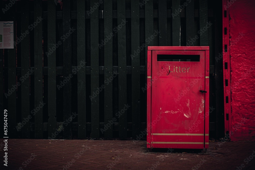 lonesome red litter post trash box in a street lonesome red litter post trash box in a street