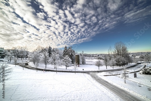 Winter landscape featuring a winding snow-covered road lined with trees in TU Clausthal, Germany.