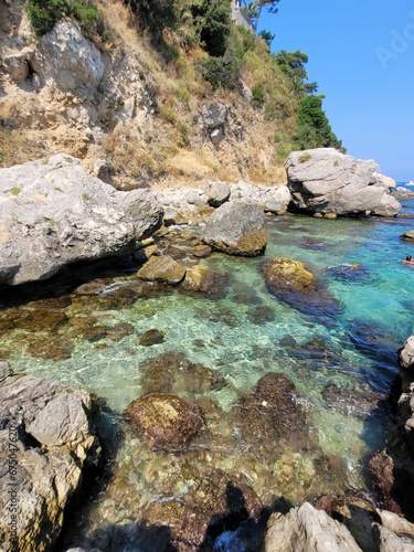 Tranquil ocean landscape featuring a rocky shoreline, captured in a vertical shot