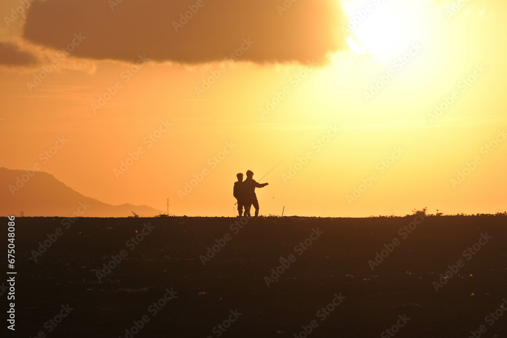 Human silhouette on a beach at sunrise.