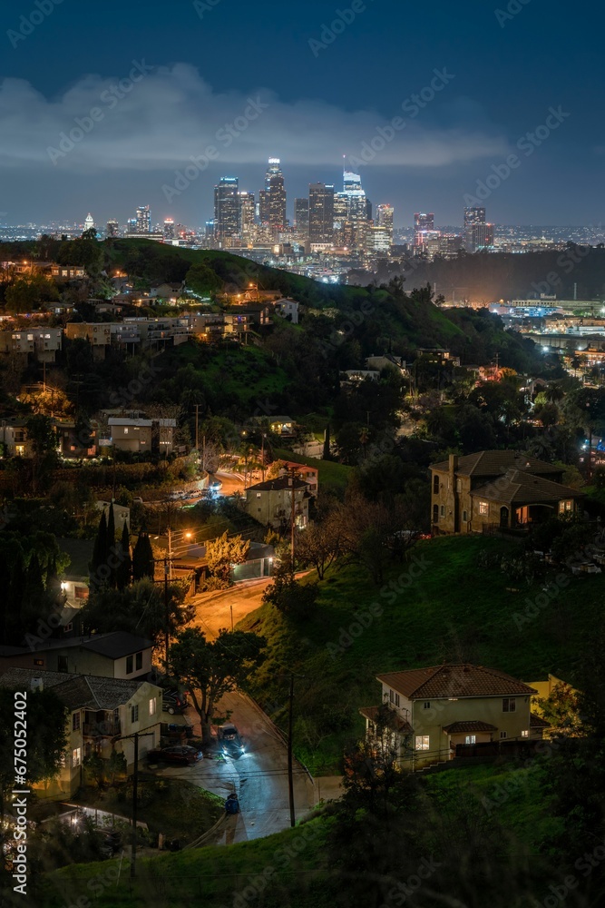 Obraz premium a view of the city of los skyline from the top of hill at night