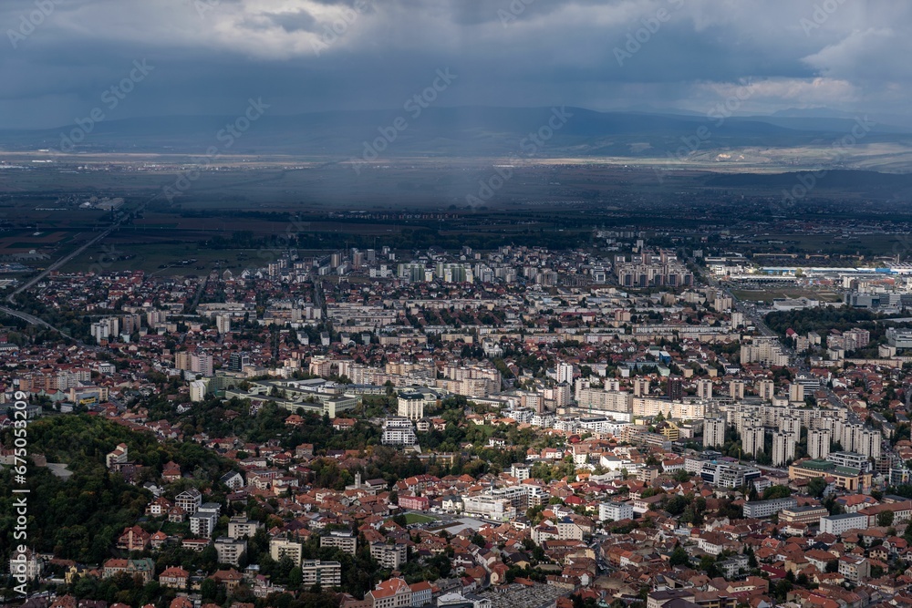 Obraz premium Aerial shot of the cityscape of Brasov, Romania under a cloudy sky.