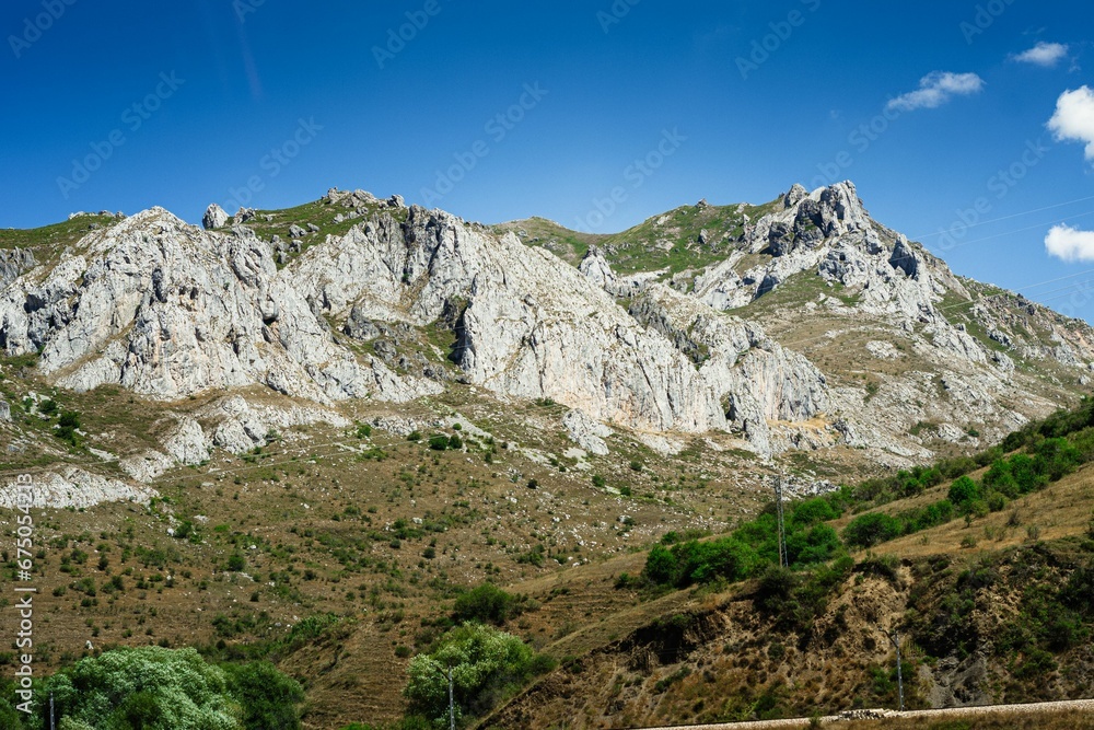 Stunning landscape of huge impressive mountains surrounded by trees in Spain.