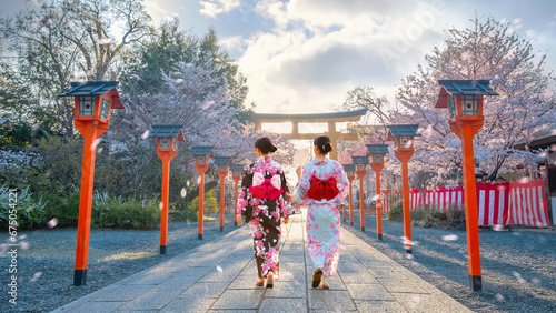 Young Japanese woman in traditional Yukata dress strolls at  Hirano-jinja Shrine during full bloom cherry blossom season