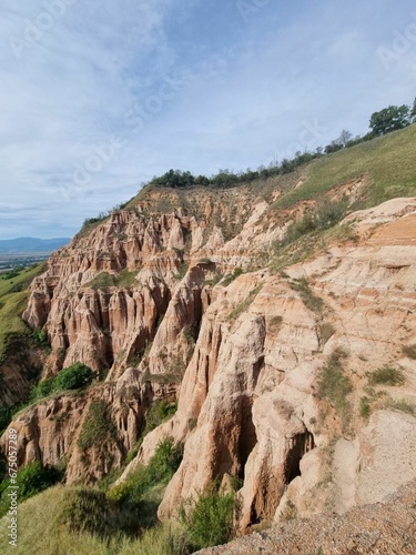 Scenic view of towering cliffs with lush green vegetation in Red Ravine, Romania.