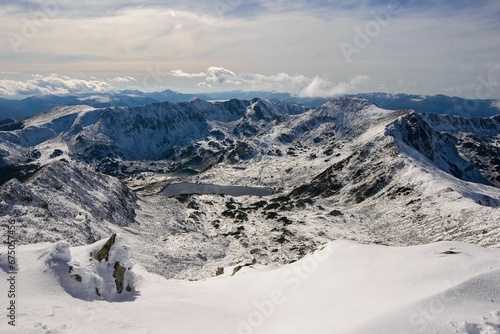 Landscape of rocky mountains covered in snow in Retezat National Park, Romania photo