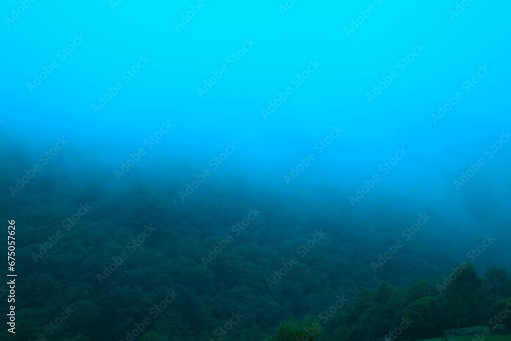 Scenic landscape of a fog-covered mountain range in the middle of the frame