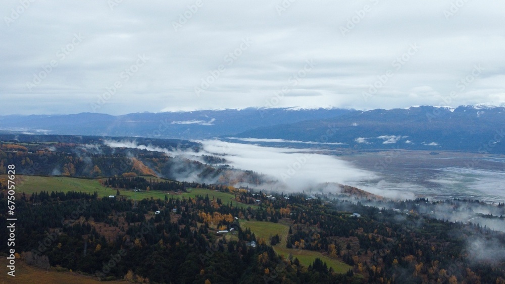 Aerial shot of Katchemak Bay in Alaska, with the stunning fall foliage and a blanket of fog