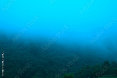 Scenic landscape of a fog-covered mountain range in the middle of the frame