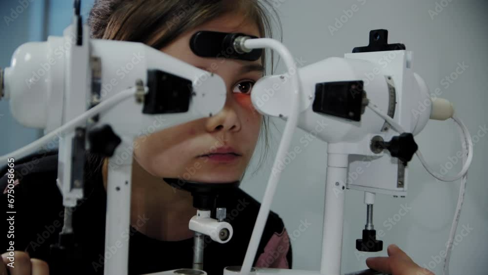 The ophthalmologist examines the young patient's eye and then looks into the camera. Close up footage The ophthalmologist examines the young patient's eye and then looks into the camera. Close up footage