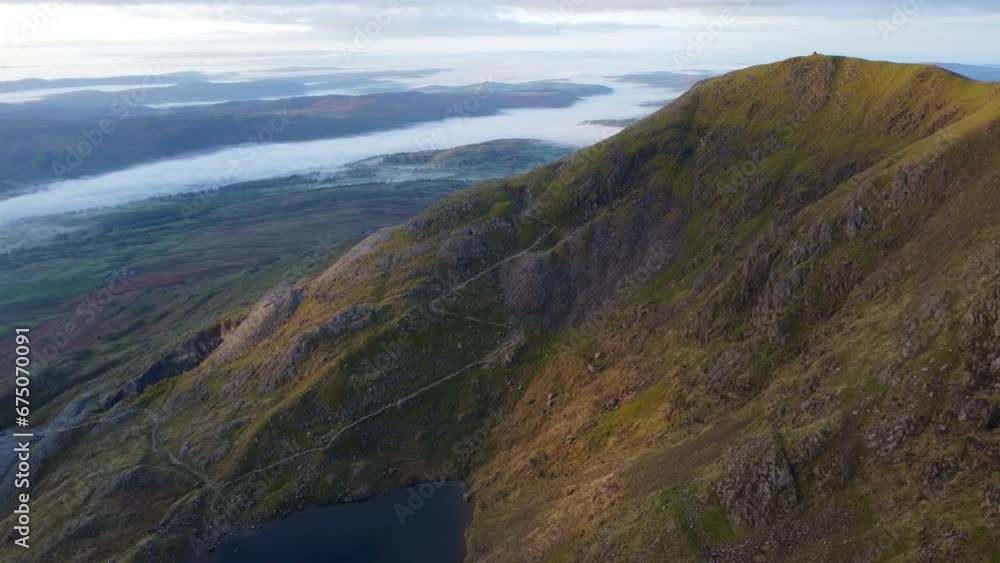 Aerial 4K drone video of mountain in golden hour with beautiful cloud inversion in valleys - taken at Old Man of Coniston, Lake District, UK Aerial 4K drone video of mountain in golden hour with beautiful cloud inversion in valleys - taken at Old Man of Coniston, Lake District, UK