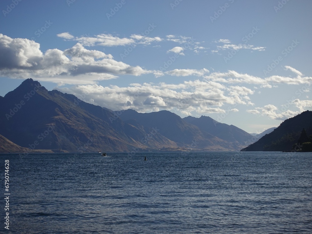 Scenic calm lake water surrounded by majestic  mountains in Queenstown New Zealand