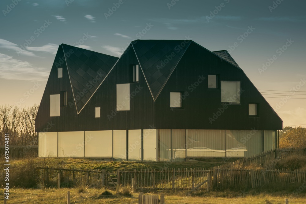 AI generated illustration of a rural house on grass fields with metal fence and cloudy sky AI generated illustration of a rural house on grass fields with metal fence and cloudy sky