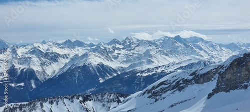 Winter scene featuring a snow-covered mountain slope with a bright blue sky in the background