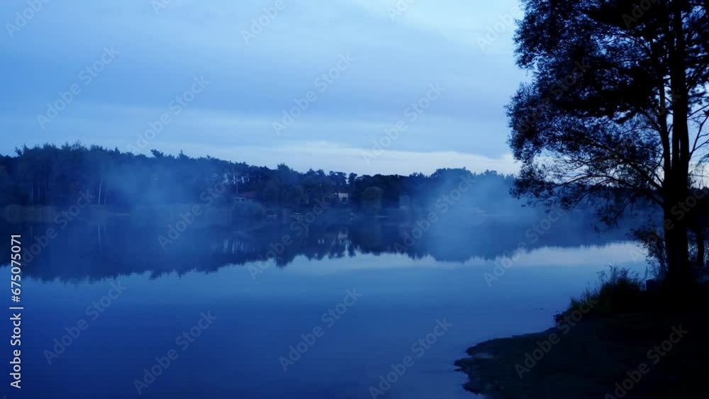 Dark evening near the lake with fog in a blue hour. Wired and scared night. Getting dark in the forest Dark evening near the lake with fog in a blue hour. Wired and scared night. Getting dark in the forest