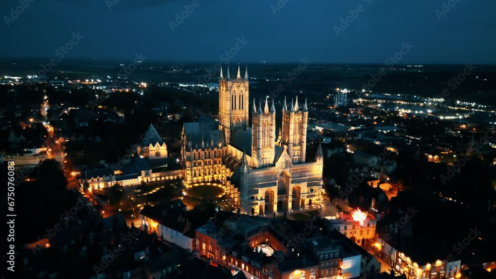 Aerial drone video captures the renowned Lincoln Cathedral in Lincolnshire, UK, at dusk, showcasing its majestic Gothic architecture with illumination. Aerial drone video captures the renowned Lincoln Cathedral in Lincolnshire, UK, at dusk, showcasing its majestic Gothic architecture with illumination.