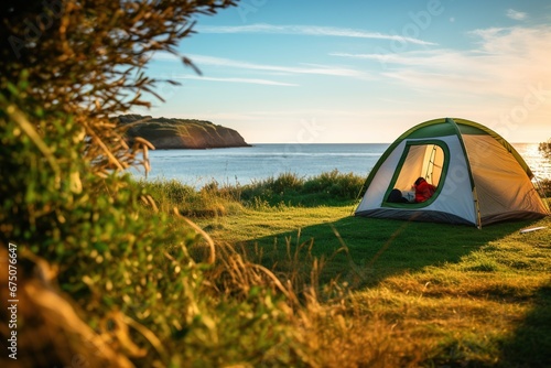 Wallpaper Mural Camping tent and camping equipment on green grass with sea view background Torontodigital.ca
