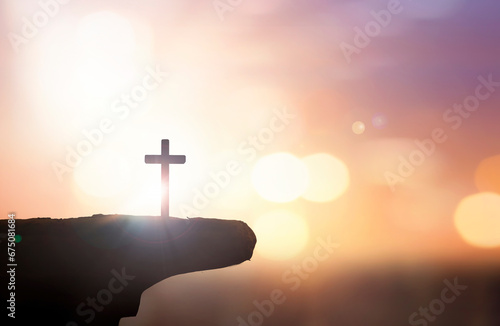Christian holding the Holy Cross of Jesus Christ on autumn sunset background