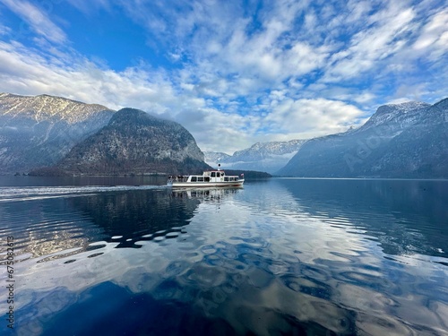 Sailboat is on a tranquil lake surrounded by a majestic mountain range photo