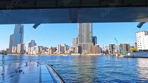 Beautiful revealing shot of modern city waterfront. view from a river cruise in Tokyo Sumida River, Japan. Skyline on a blue sky day. View from the water photo