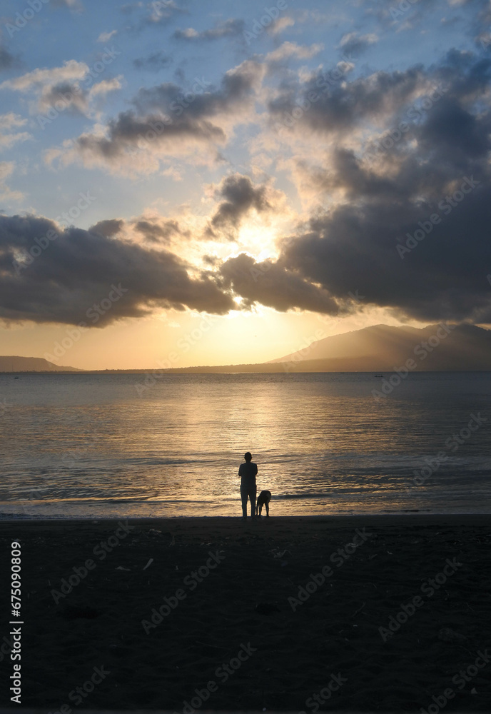 Human silhouette on a beach at sunrise.