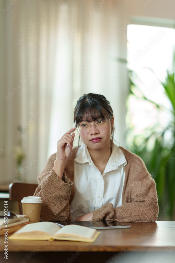 Asian female office worker uses her thoughts and ideas to read a book in a relaxed manner. and take notes for review Planning at work work from home via the internet online. Asian female office worker uses her thoughts and ideas to read a book in a relaxed manner. and take notes for review Planning at work work from home via the internet online.