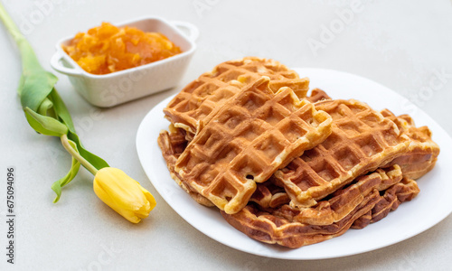A delicious plate of waffles on a table decorated with flowers