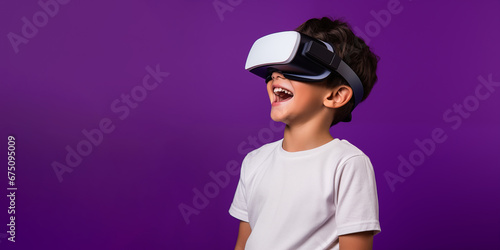 Young boy getting experience using VR headset glasses isolated on a purple background with copy space © dewaai