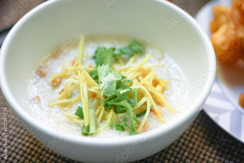 Joke or Congee in a Thai style cup Served on a wooden table. It's an Asian breakfast.