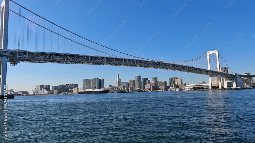 View on the famous Rainbow Bridge in Tokyo above the bay of Sumida River and Toyko. View along the bridge, low angle View on the famous Rainbow Bridge in Tokyo above the bay of Sumida River and Toyko. View along the bridge, low angle