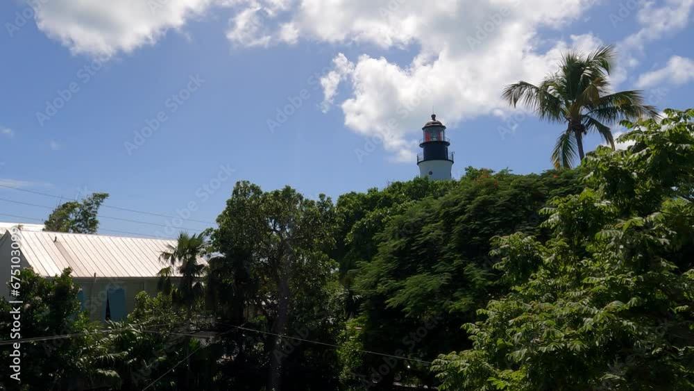 Key West Lighthouse amidst tropical trees, blue sky backdrop, Florida Key West Lighthouse amidst tropical trees, blue sky backdrop, Florida
