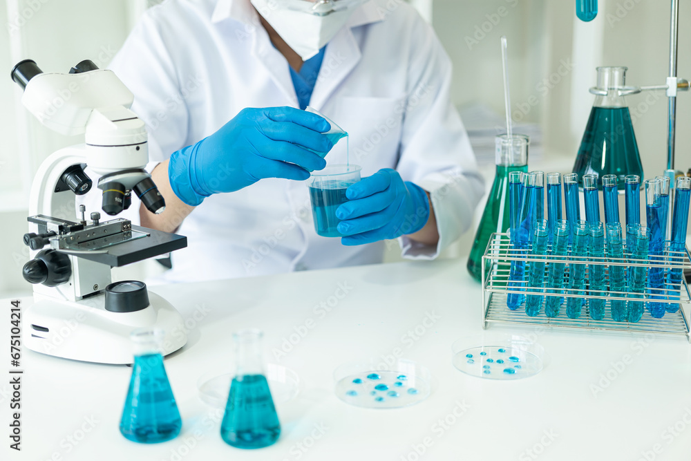 Fototapeta premium Doctor in mask examining DNA molecule in chemistry lab with scientist examining liquid sample with microscope in chemistry lab Researcher working with sample