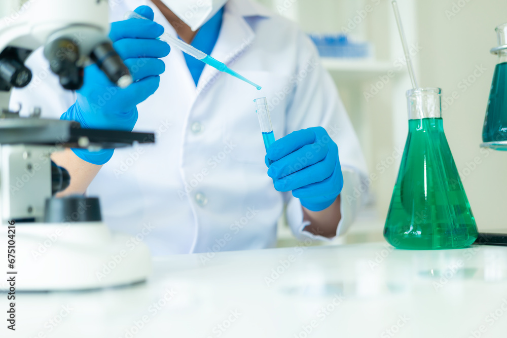 Fototapeta premium Doctor in mask examining DNA molecule in chemistry lab with scientist examining liquid sample with microscope in chemistry lab Researcher working with sample