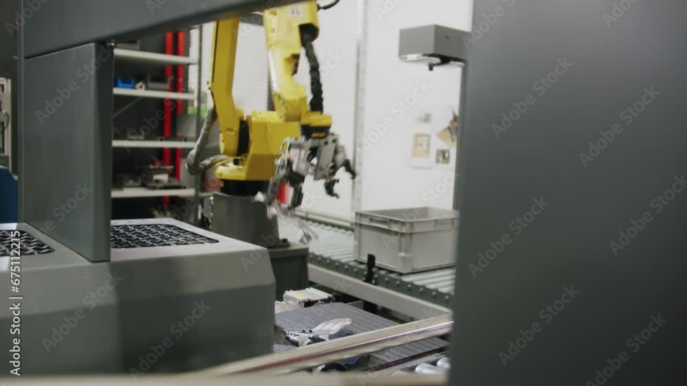 An industrial robotic arm takes a car part from the conveyor belt and transfers it to the next step in the factory process An industrial robotic arm takes a car part from the conveyor belt and transfers it to the next step in the factory process