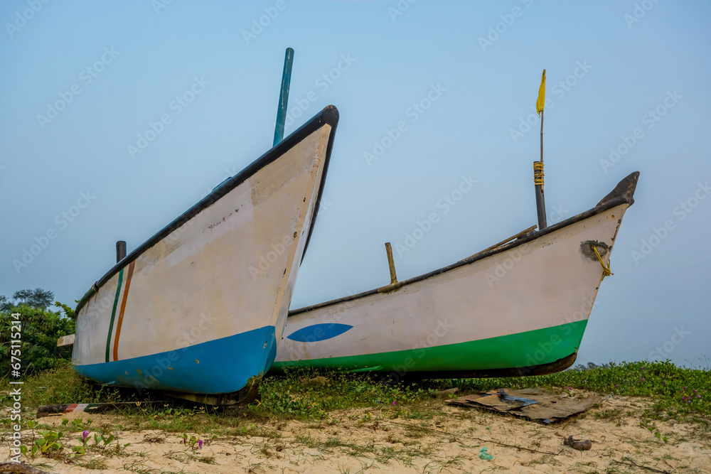 old fishing boats in the sand on the ocean in India on blue sky background