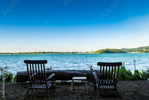 two chairs and a table overlooking the sea
